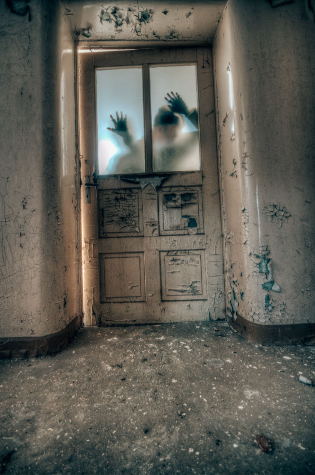 Person standing spookily behind a door