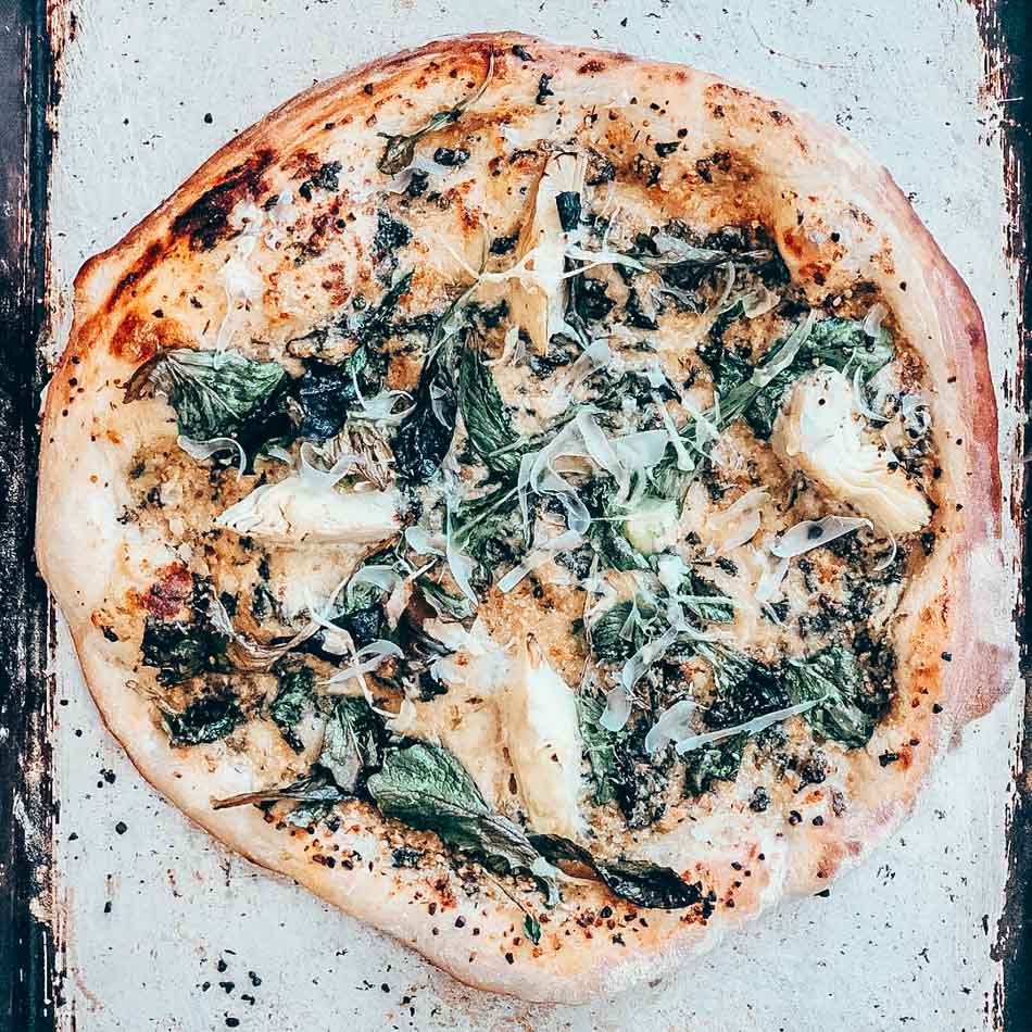 vegan spinach artichoke pizza from half peach bakery in louisville ky